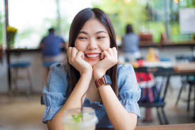 Beautiful asian women sitting in coffee shop blurred people in background