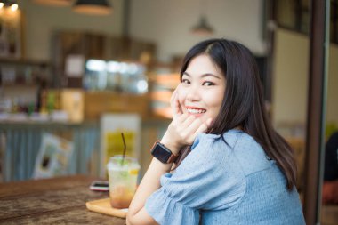 Beautiful asian women sitting in coffee shop blurred people in background