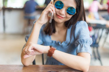 Business women use smartphone in coffee shop background with people