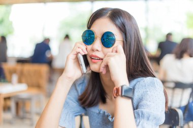 Business women use smartphone in coffee shop background with people
