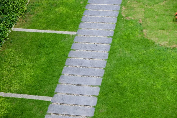 緑の芝生の庭のセメントの散歩道 — ストック写真