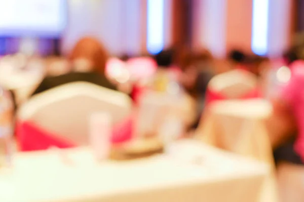 Abstract blurred people sitting in seminar hotel ballroom businesss background