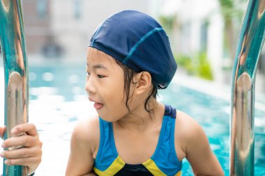 Little asian kindergarten girl practice swim in swimming pool outdoor sport