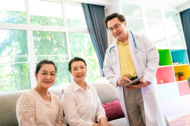 Keyifli doktor, klinikte yaşlı kadınlarla ilgileniyor.