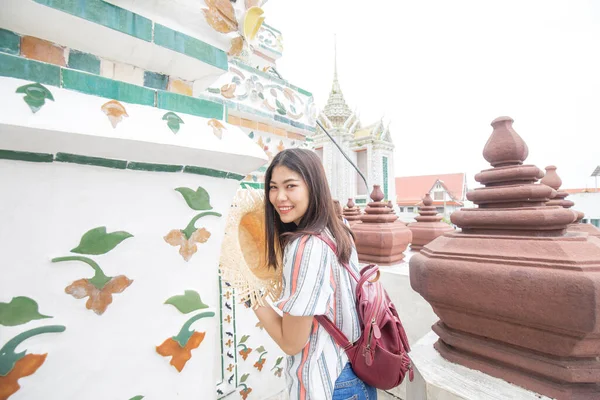 Beautiful asian women travel in buddhist temple backpack solo travel in Bangkok Thailand