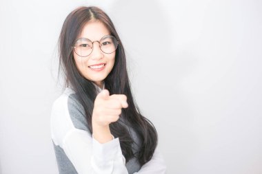 Güzel, gülümseyen kadınlar beyaz arka planda el işareti gösterir, gözlüklü kız.