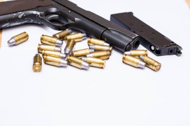 .45 ACP tabancası, beyaz arka planda metal kurşun kaplama kurşun kol kavramı.