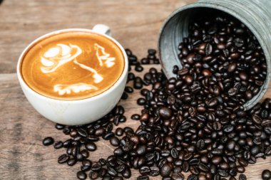 Kahve fincanı ve kahve çekirdeği, ahşap masa içeceği endüstrisi objesi.