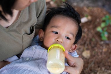 Küçük bebek anne tarafından emzirilen anne tarafından açık hava doğa ağacı.