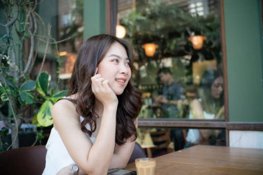 Beautiful asian women sitting in cafe with hot latte art coffee smiling women