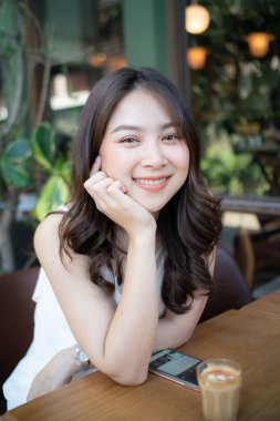 Beautiful asian women sitting in cafe with hot latte art coffee smiling women