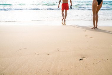 Couple walking on sea beach into the sea summer beach