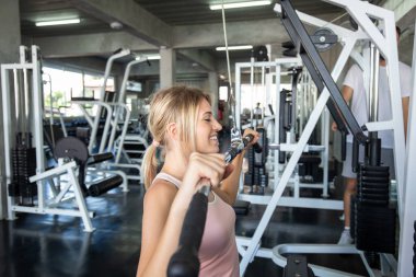 Sport women working out with pull barbell in  fitness gym Healthy women