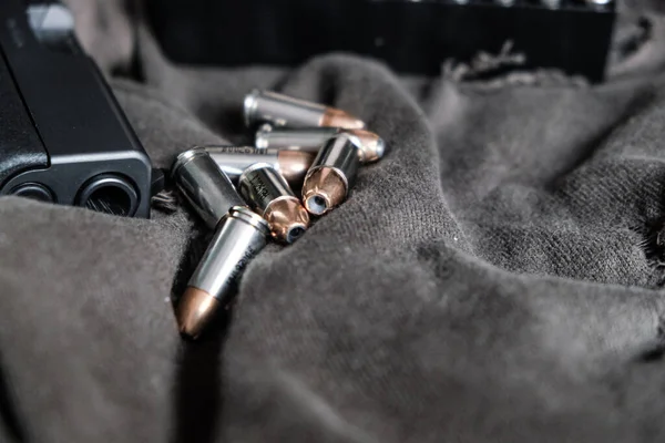 9mm conceal semi automatic gun with jacket hallow point bullet on cloth background