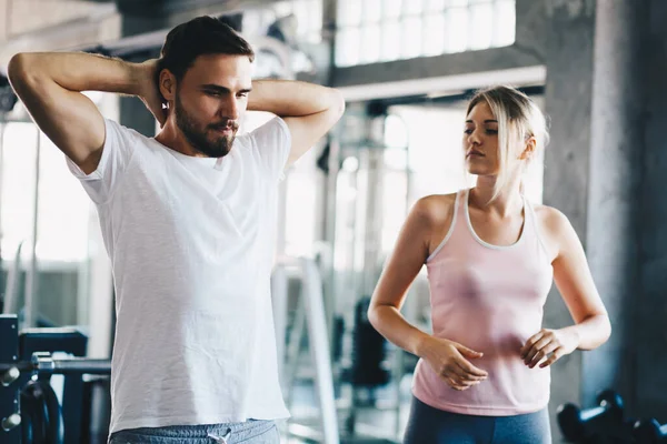 Sport men and women doing stretch before exercise in fitness gym healthy lifestyle