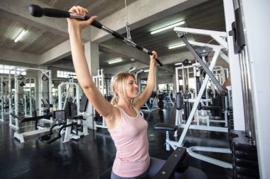 Sport women working out with pull barbell in  fitness gym Healthy women