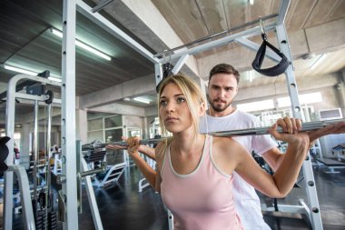 Sport women working out with pull barbell in  fitness gym Healthy women