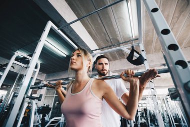 Sport women working out with pull barbell in  fitness gym Healthy women