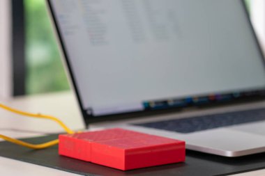External hard drive connect to laptop computer working on table storage concept