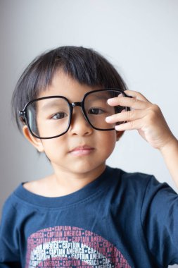 Happy facial face of little boy with big glasses on white background funny emotion