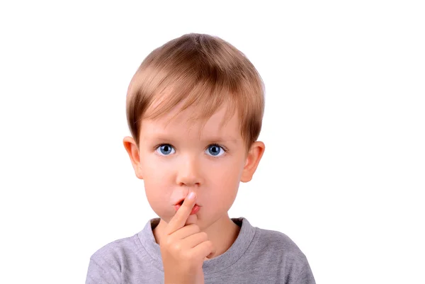 Boy covers up his mouth with finger — Stock Photo, Image