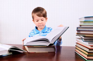 küçük çocuk açar bir büyük kitap ve araştırıyor