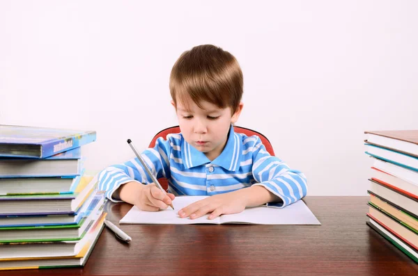 Мальчик пишет в тетрадь — стоковое фото