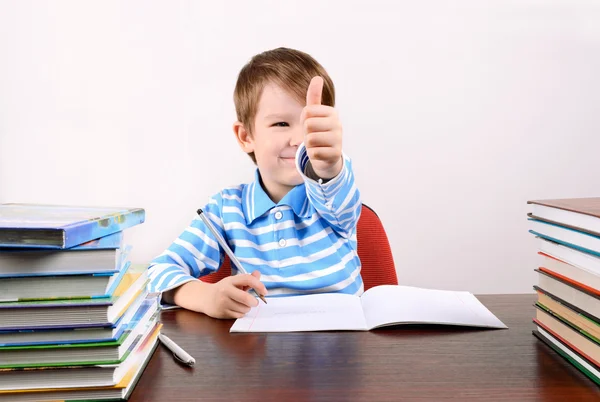 Boy at the desk shows a hand with a thumb up — Stock Photo, Image