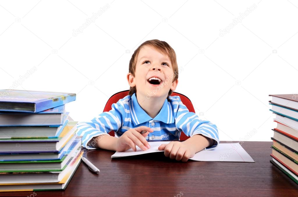 boy laughing while sitting at the desk