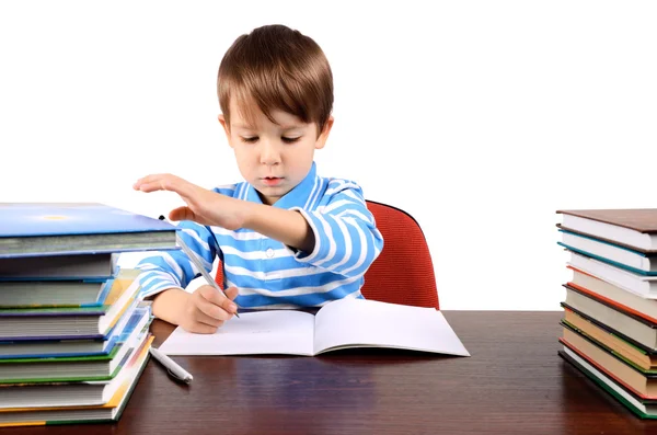 Chico escribe y toma un libro al mismo tiempo — Foto de Stock