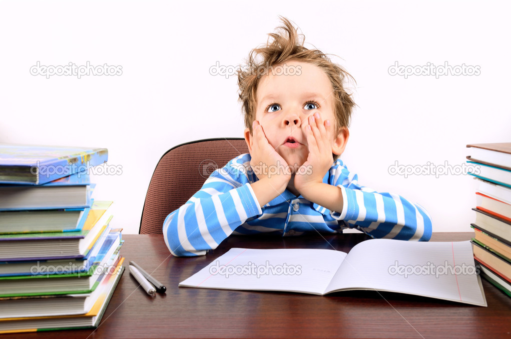 Boy with tousled hair sitting at a desk