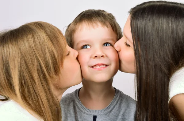 Duas meninas beijando pouco sorrindo menino — Fotografia de Stock