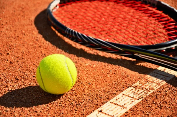 Palla da tennis e racchetta è sul campo tappeto primo piano — Foto Stock