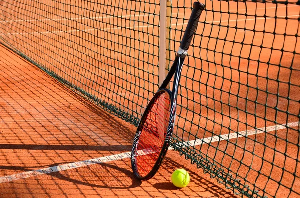 La pelota de tenis y la raqueta están cerca de la vista lateral horizontal de la red — Foto de Stock