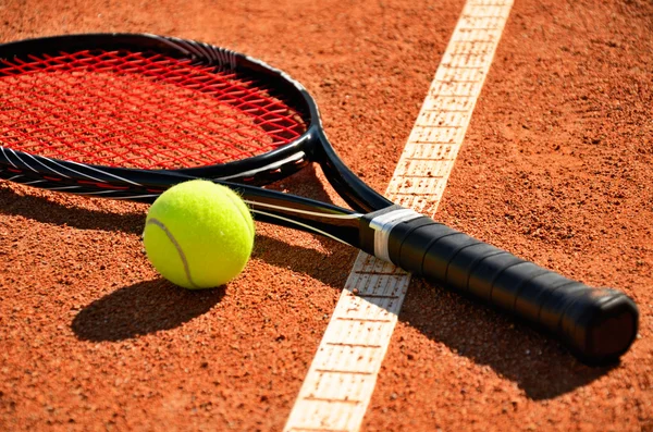 Pelota de tenis y raqueta está en la cancha de alfombras — Foto de Stock