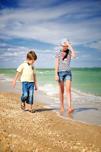 Kinderen lopen langs de kust verticale — Stockfoto