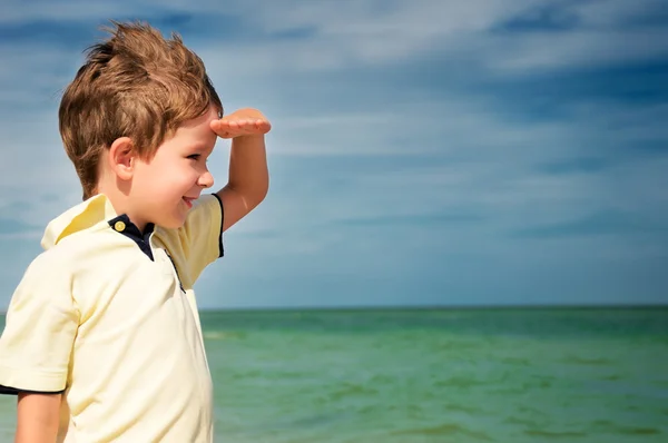 Lächelnder Junge, der von seiner Handfläche auf dem Hintergrund des Clou wegschaut — Stockfoto