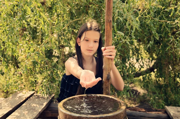 Water flows from the girl's hands toned — Stock Photo, Image