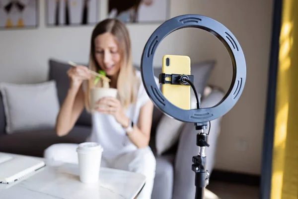 Jovem mulher fazendo conteúdo de foto ou vídeo para mídias sociais com smartphone e luz da lâmpada do anel. Influenciador Faz transmissão se comunica com seguidores em redes sociais — Fotografia de Stock