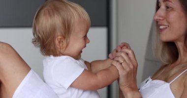 Sevimli küçük kız bebek evde beyaz bir anneyle kek oynuyordu. Mutlu bir aile annesi ve tatlı bir oğlan çocuğu eğlenceli bir oyun öğreniyorlar birlikte güzel anların tadını çıkarıyorlar.