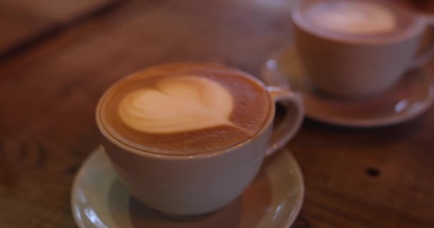 Tazza bianca con cappuccino caffè per la prima colazione su sfondo bianco in legno in caffè moderno. Rallentatore — Video Stock