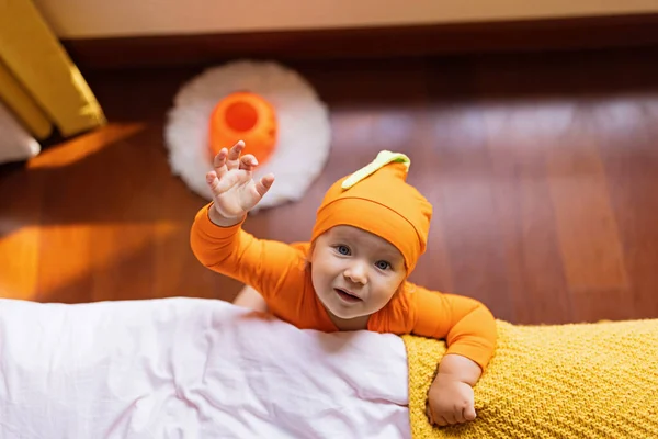 Bonito bebê infantil caucasiano Menina de um ano de idade em traje laranja com rosto de abóbora em casa. Feliz conceito de Halloween — Fotografia de Stock
