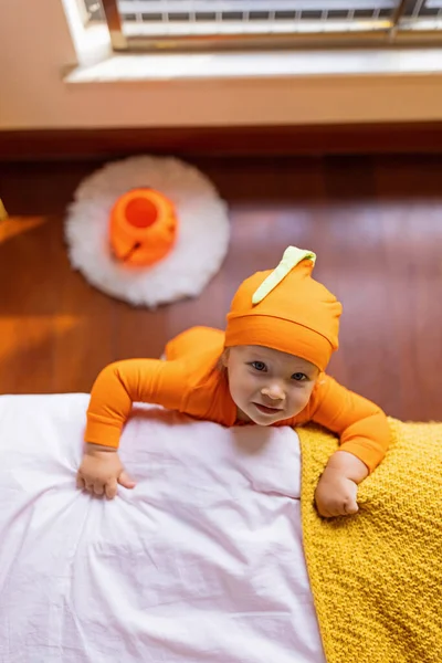 Bonito bebê infantil caucasiano Menina de um ano de idade em traje laranja com rosto de abóbora em casa. Feliz conceito de Halloween — Fotografia de Stock