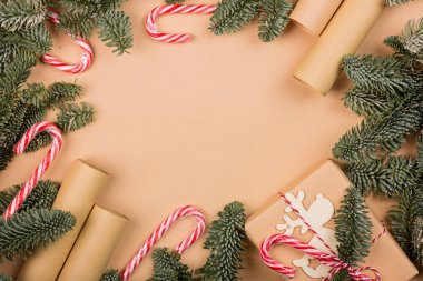 Noel kompozisyonu. El işi kağıdına sarılı hediye kutusu, köknar ağacı dalları, şeker kamışı. Yeni yıl konsepti. Kutlama kartı, Xmas Kutlaması 2021. Düz konum, üst görünüm, kopyalama alanı, modelleme