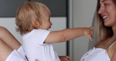 Sevimli küçük kız bebek evde beyaz bir anneyle kek oynuyordu. Mutlu bir aile annesi ve tatlı bir oğlan çocuğu eğlenceli bir oyun öğreniyorlar birlikte güzel anların tadını çıkarıyorlar.
