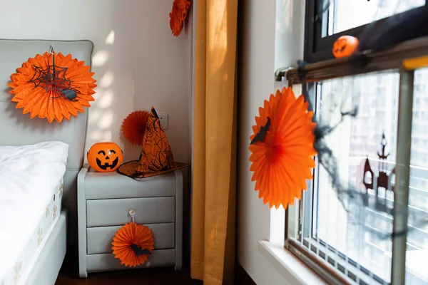 Decoração para casa para a celebração de Halloween com papel grinalda cor laranja, morcego na janela — Fotografia de Stock