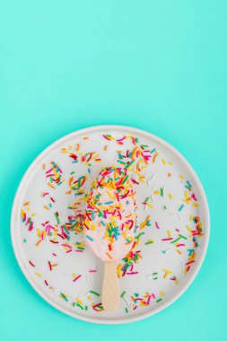 Mavi arka planda pembe çilekli dondurmanın parlak ve renkli yatağı. Sağlıklı yaz yemekleri konsepti. Buzlu şekerin en üstteki görüntüsü serpiştirilmiş, üstte.