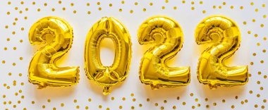 Folyo balonları 2022 numaralı formda altın renginde. Yeni yıl kutlaması, Noel, Noel. Hava Balonlarıyla yatıyordu, üst görünüm, model, genel görünüş, asgari tarz. Tatil partisi dekorasyonu.