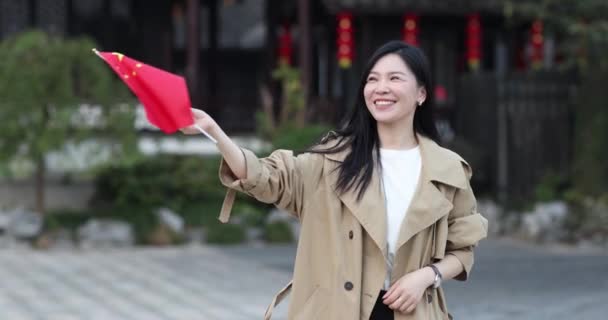 Heureuse jeune femme asiatique tenant la main Drapeau national chinois en plein air. Personne célébrant la fête nationale le 1er octobre ou le Nouvel An chinois 2022. Mouvement lent — Video