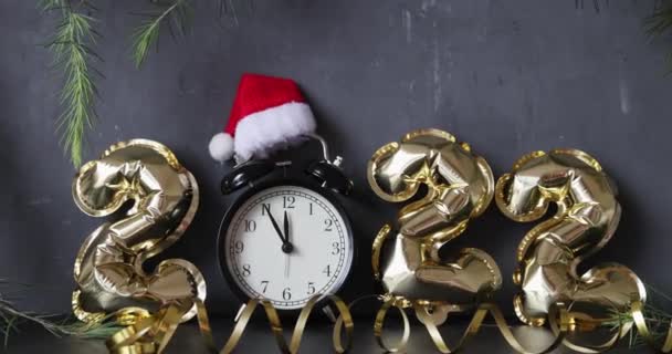 Felice anno nuovo 2022 sfondo. Palloncini metallici color oro su cemento grigio con coriandoli. Festa delle vacanze invernali. — Video Stock